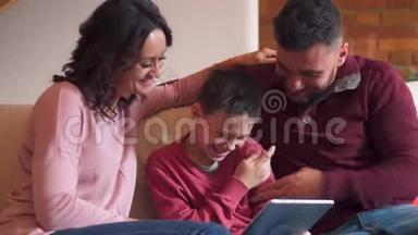 家庭在家里沙发上使用数码平板电脑时玩得开心