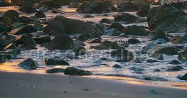 在哥斯达黎加的一个黑沙滩上，海浪冲破岩石。