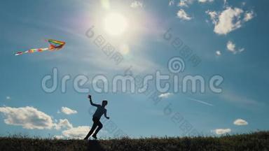 一个男孩带着风筝跑过田野。 梦想飞翔，孩子们`游戏