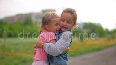 两个微笑、卷曲、可爱的姐妹紧紧地拥抱着对方。 快乐童年，积极情绪，真情实感..