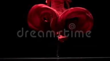弗拉门戈。 舞蹈演员在音乐的<strong>节奏</strong>中发展她的r裙。 黑色背景。 快关门。 慢动作