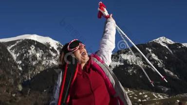 身穿滑雪服、戴着镜子眼镜、手里拿着滑雪板和滑雪杆的卷发女孩大声欢呼并战胜了对手