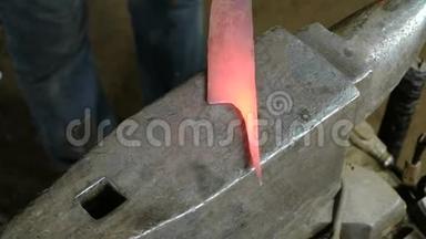 在锻造厂用金属制造刀。 紧紧抓住铁匠`他的手拿着锤子，用铁水<strong>打铁</strong>