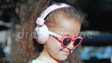 一个可爱的孩子的肖像，一个穿着<strong>粉色</strong>眼镜和<strong>粉色</strong>耳机的白色裙子的美丽的小女孩