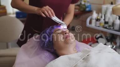 美容技术概念-美容师与微磨擦装置做面部去角质年轻妇女