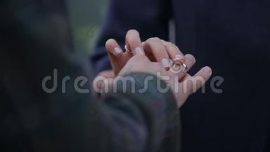 新娘在新郎`手指上戴戒指。 有戒指的婚姻之手。 <strong>结婚纪念</strong>日。