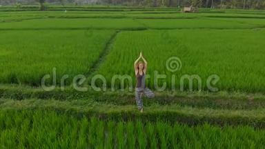 日出日落时分，一名女子在奇妙的稻田上练习瑜伽