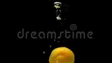 成熟的杏子在黑色的背景上落入透明的水中