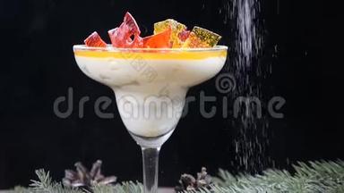 用冷杉树枝和柠檬片装饰在木板上的玻璃碗中的美味甜点特写镜头