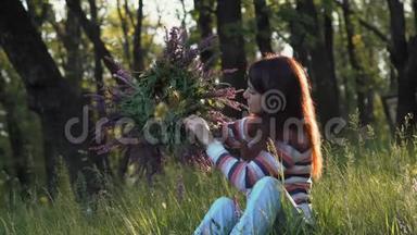 美丽的女孩在森林的一片草地上，在早晨坐着一朵<strong>迎春花</strong>