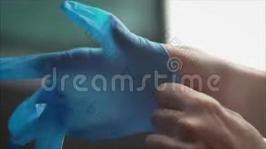 牙医戴蓝色橡胶手套。 蓝手套穿着医生。 英俊的年轻医生在医院或诊所戴橡胶手套