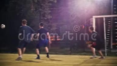年轻人踢了一个球，从其他足球运动员身边飞过，经过大<strong>门</strong>，晚上踢足球