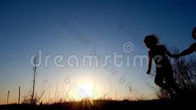 母亲、父亲和女儿在日落时奔跑和玩耍的剪影