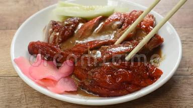 <strong>烤鸭</strong>肉和腌制姜汁，用筷子在盘子上采摘