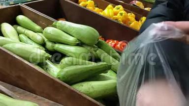 在超市选择西葫芦的女人。 把绿色蔬菜南瓜送到塑料包里。 食品购物