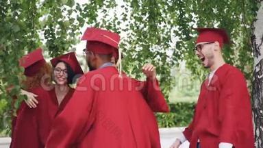喜气洋洋的男女<strong>毕业</strong>生穿着长袍戴着帽子，在<strong>毕业</strong>典礼上互相拥抱祝贺，欢笑和欢笑