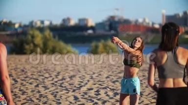 在沙滩排球比赛中，留着长发的美丽苗条的女孩打球