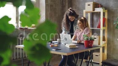 小企业的年轻业主正在现代阁楼风格的办公室里使用笔记本电脑。 金发女郎坐着打字