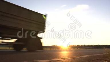 现代货车在日落的背景下运输货物。 卡车司机的概念