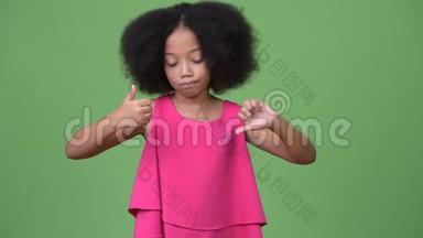 一个年轻的、头发凌乱的非洲女孩，在<strong>竖</strong>起<strong>大拇指</strong>或<strong>竖</strong>起<strong>大拇指</strong>之间做出选择