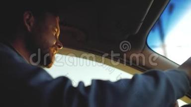 一个长着漂亮眼睛的胡子的人在开车。 窗外的阳光