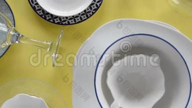 不同的<strong>瓷盘</strong>和酒杯在新鲜的黄色背景上
