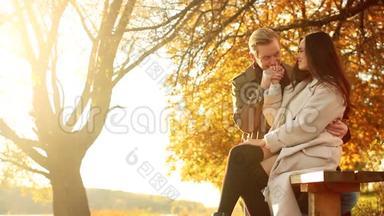 可爱的一对夫妻在一起：有魅力的男人牵着女朋友`手，用大爱看着她，坐着