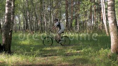 在一个阳光明媚的日子里，运动员骑自行车穿过森林。 <strong>心情舒畅</strong>，身体健康..