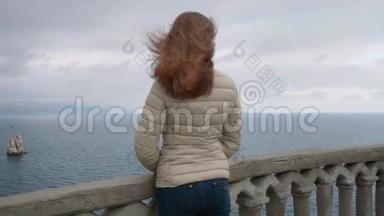 大<strong>风天</strong>，站在阳<strong>台</strong>上，一个长着棕色头发的瘦小女子望着大海
