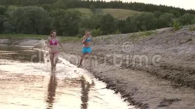 夏天，穿着泳衣的年轻女孩沿着海滩跑来跑去，笑了起来。 快乐的孩子们赤脚跑在河岸上
