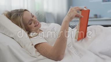 笑着高兴的少女在看一本关于<strong>浪漫爱情</strong>的小说，躺在床上