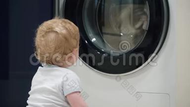 一岁男孩在家看洗衣机。 家用电器问题