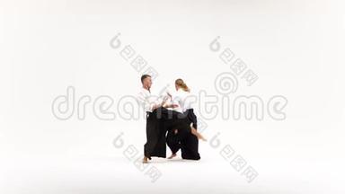 两个穿和服的男人练习合气道的技巧，被隔离在白色上。