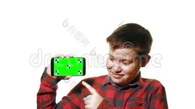 开朗的男孩手里拿着一部智能手机，手里拿着一个<strong>绿</strong>色的<strong>屏</strong>幕，<strong>屏</strong>幕上显示着一个手指。