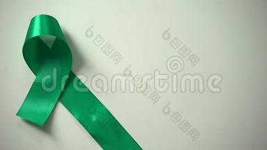 桌子上的绿色丝带，世界心理健康日，提高认识运动，容忍