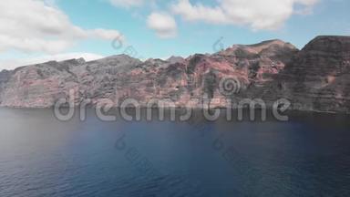 空中射击。 巨大的<strong>黑</strong>红色火山岩是海洋蓝色水域中的一座山。 对着蓝天。 加那利