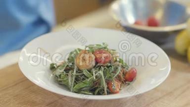 在厨房的桌子上放一个白色的<strong>大盘</strong>子里，配上、虾、番茄和橄榄油的美味沙拉。 食物