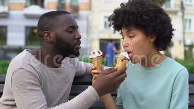 在城市公园的夏日约会期间，爱情伴侣分享冰淇淋，一起玩