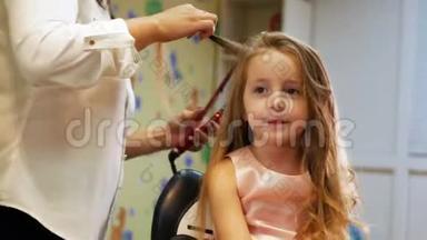 美发师是为小可爱女孩卷发，使用电卷发铁。 投中弹