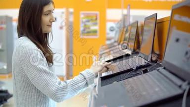 家用电器商店。 年轻女子选择笔记本电脑