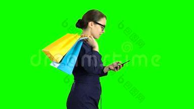 戴眼镜的女孩拨<strong>通电</strong>话里的信息，去商店，她从购物中心情很好。 绿色屏幕