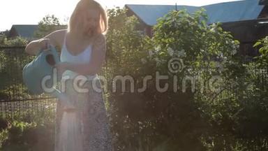 女人用浇水罐给阳光明媚的花园浇水