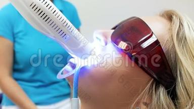特写4k视频：年轻金发女子戴<strong>防紫外线</strong>眼镜坐在牙医椅上