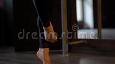 舞女光着脚在芭蕾酒吧的地板上奔跑
