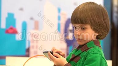 可爱的小男孩使用智能手机。 机器人在第四届俄罗斯科学节为孩子们演示。 活动的目的是