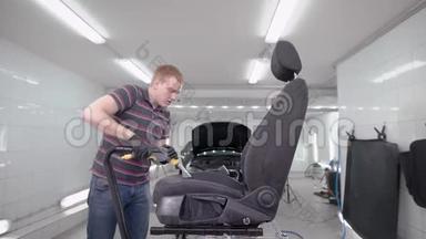 红发男子正在清洁、<strong>洗车</strong>期间，在一间<strong>自动</strong>服务的房间里徘徊着黑色的汽车座椅