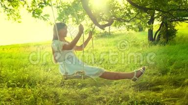 美丽的女孩，一头长发，穿着白色连衣裙，在灿烂的金色夕阳中荡秋千，在<strong>夏日</strong>的橡<strong>树下</strong>微笑