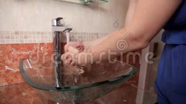 一个<strong>年</strong>轻的女孩站在浴室里，用透明的水盆洗手