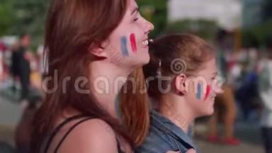 快乐的女孩为法国队看比赛欢呼。 侧视图