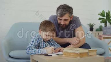 快乐的孩子<strong>勤奋</strong>的学生正在做作<strong>业</strong>，和他的父亲交谈，小男孩在学习，爸爸在教书